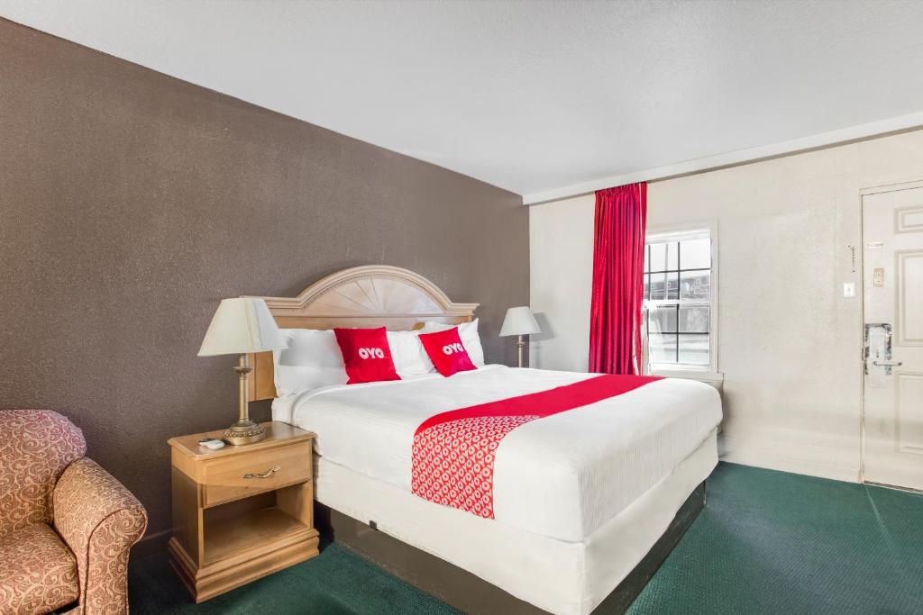 a bedroom with a large bed with red pillows at OYO Hotel Bald Knob near Searcy AR in Bald Knob