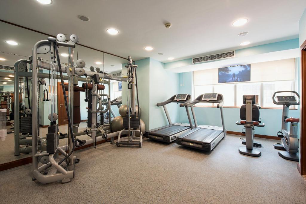 a gym with several tread machines in a room at Al Rawda Arjaan by Rotana, Abu Dhabi in Abu Dhabi