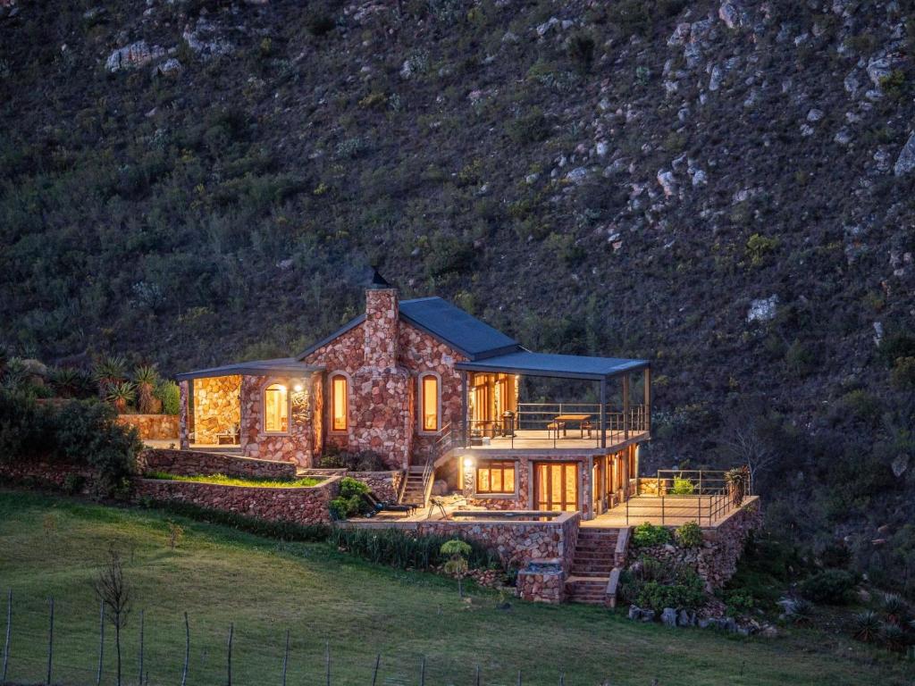 una gran casa de piedra con luces encendidas en Die Beloofde Land, en Uniondale