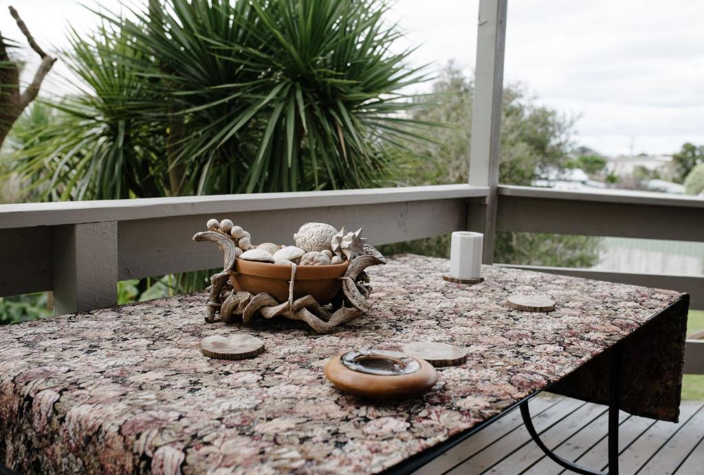 a table with a bowl of shells on a balcony at Apollo Stay in Apollo Bay