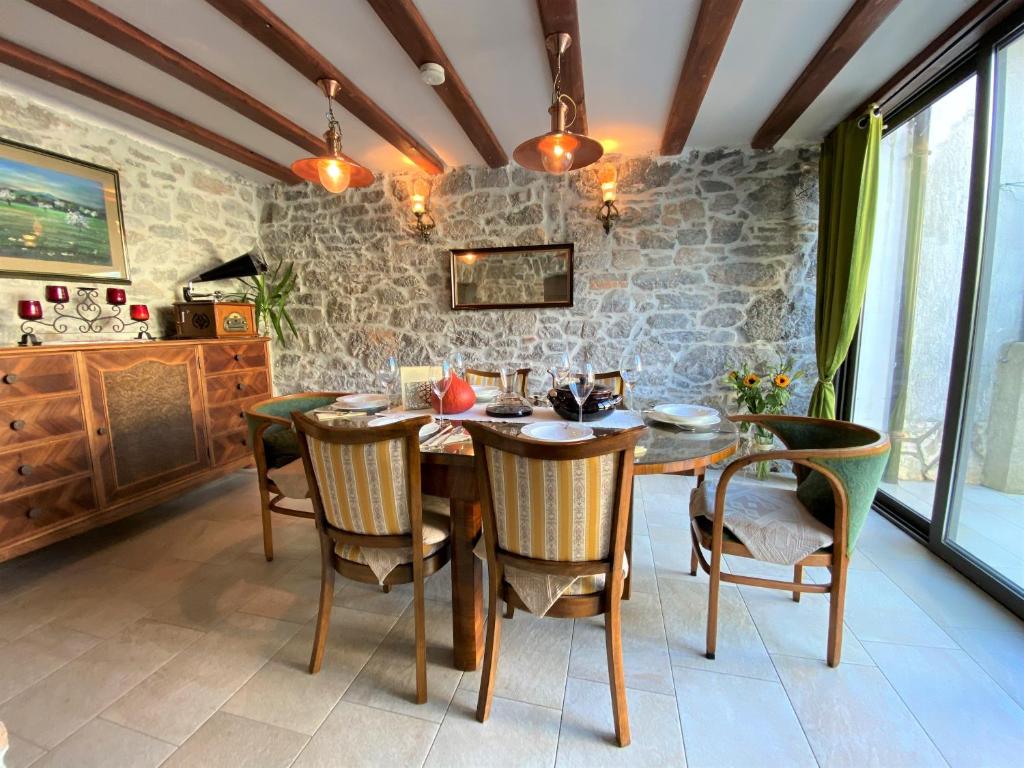 a dining room with a wooden table and chairs at VILLA SALVIA - Holiday house with pool - in Jurdani