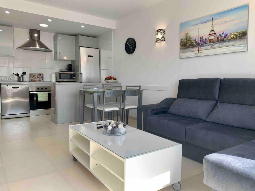 ein Wohnzimmer mit einem blauen Sofa und einem Tisch in der Unterkunft Aquamarina Beach in Alcúdia