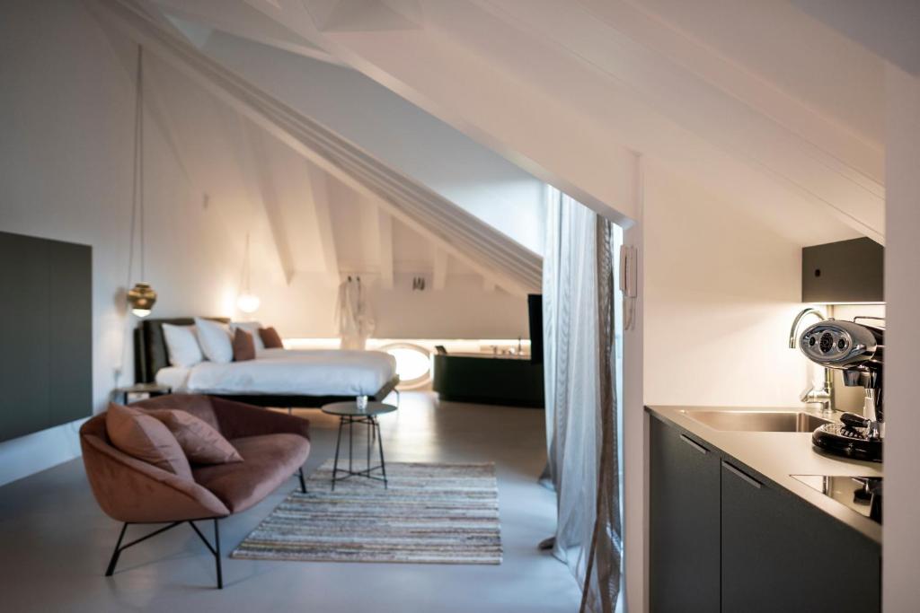 Una sala de estar con una cama y una silla en una habitación. en Gius La Diffusa, en Caldaro