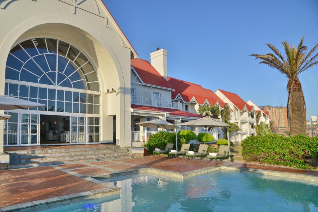 un hotel con piscina di fronte a un edificio di Courtyard Hotel Gqeberha a Port Elizabeth