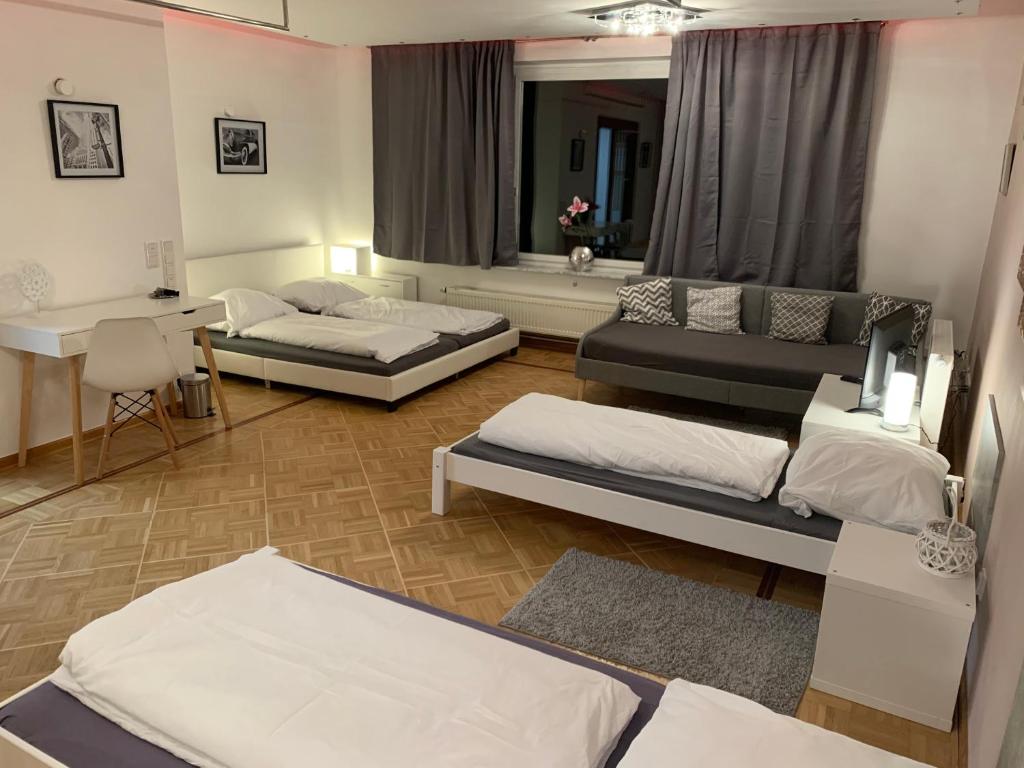 Sala de estar con 3 camas y mesa en AschaffApartment 4 Schlafzimmer bis 10 Personen bei Aschaffenburg, en Mainaschaff