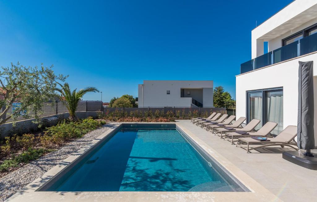 basen z leżakami obok domu w obiekcie Villa Sandi w mieście Novigrad