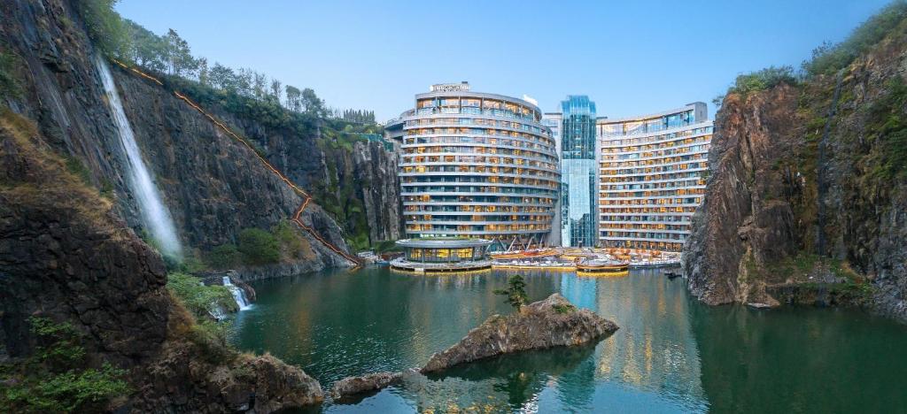 - une vue sur une rivière avec une cascade et des bâtiments dans l'établissement InterContinental Shanghai Wonderland, an IHG Hotel, à Songjiang