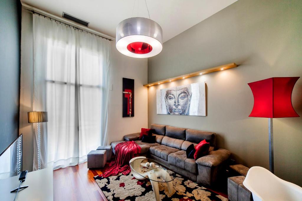 a living room with a couch and a red lamp at Victoria City Center Barcelona in Barcelona