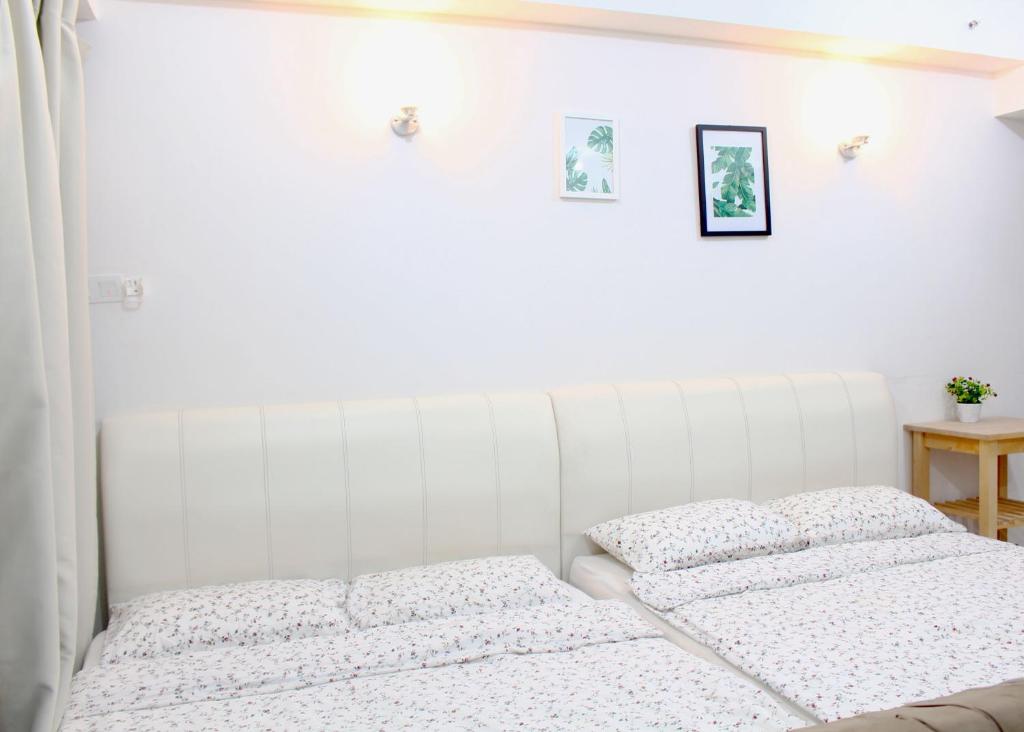 two beds in a bedroom with white walls at One O' Three Studio Apartment @D'Perdana Kota Bharu in Kota Bharu