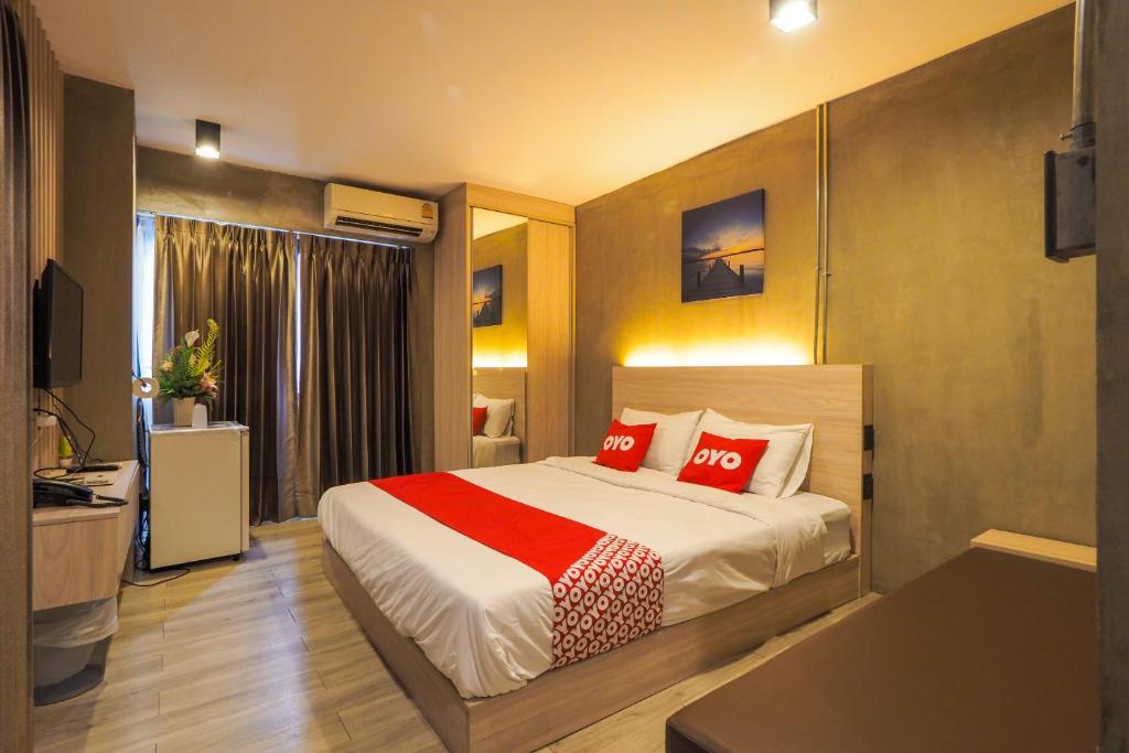 een slaapkamer met een groot bed met rode kussens bij OYO 75368 Demadre Resort in Ban Ko