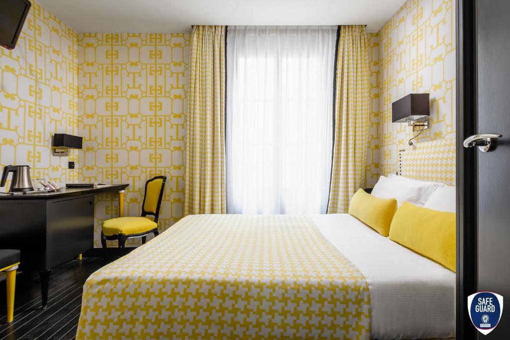una camera d'albergo con letto e scrivania di Monceau Elysées a Parigi