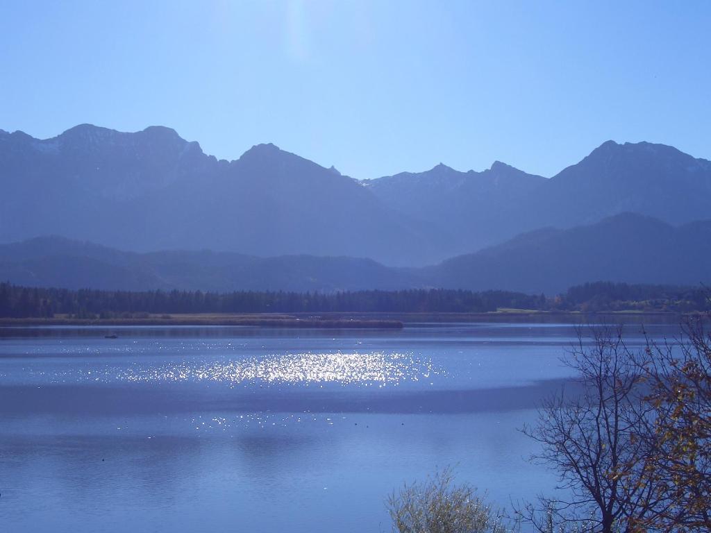 ein großer Wasserkörper mit Bergen im Hintergrund in der Unterkunft Gästehaus Guggomos "Hopfen am See" in Füssen