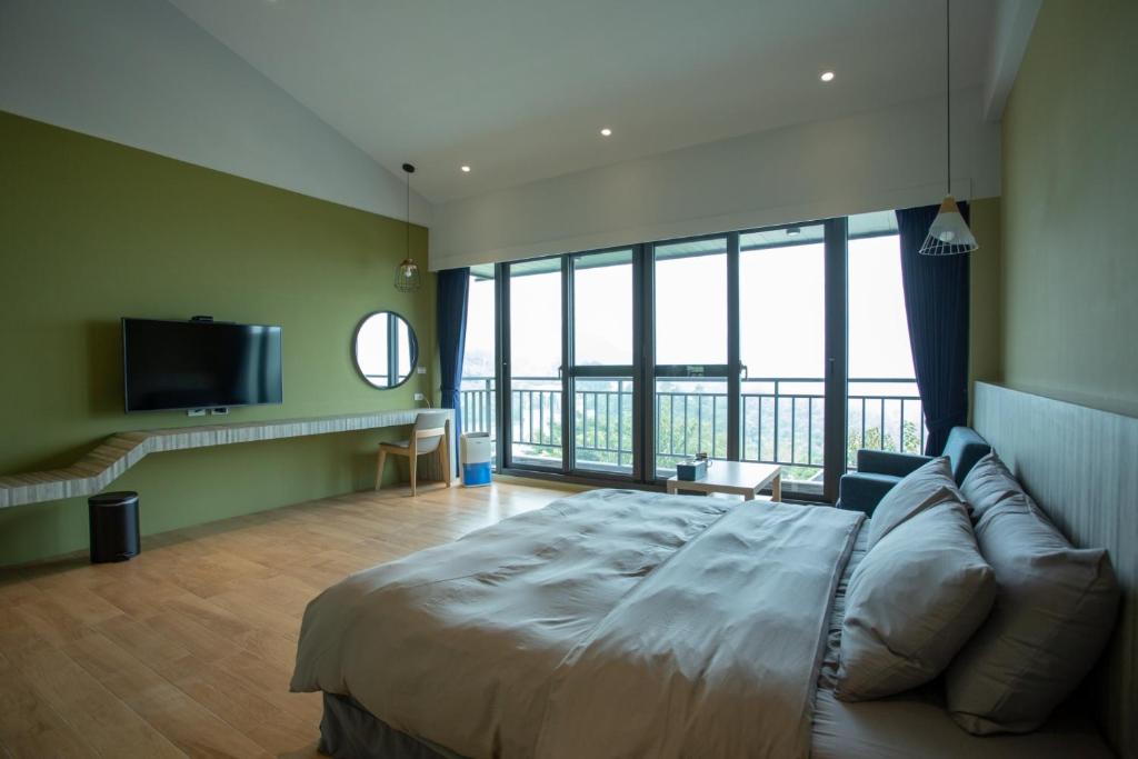 1 dormitorio con 1 cama grande y TV en 茶緣觀舍民宿 en Fanlu