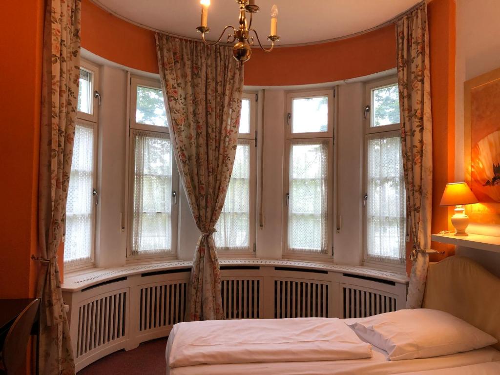 1 dormitorio con ventanas y 1 cama. en Hotel Galleria en Múnich