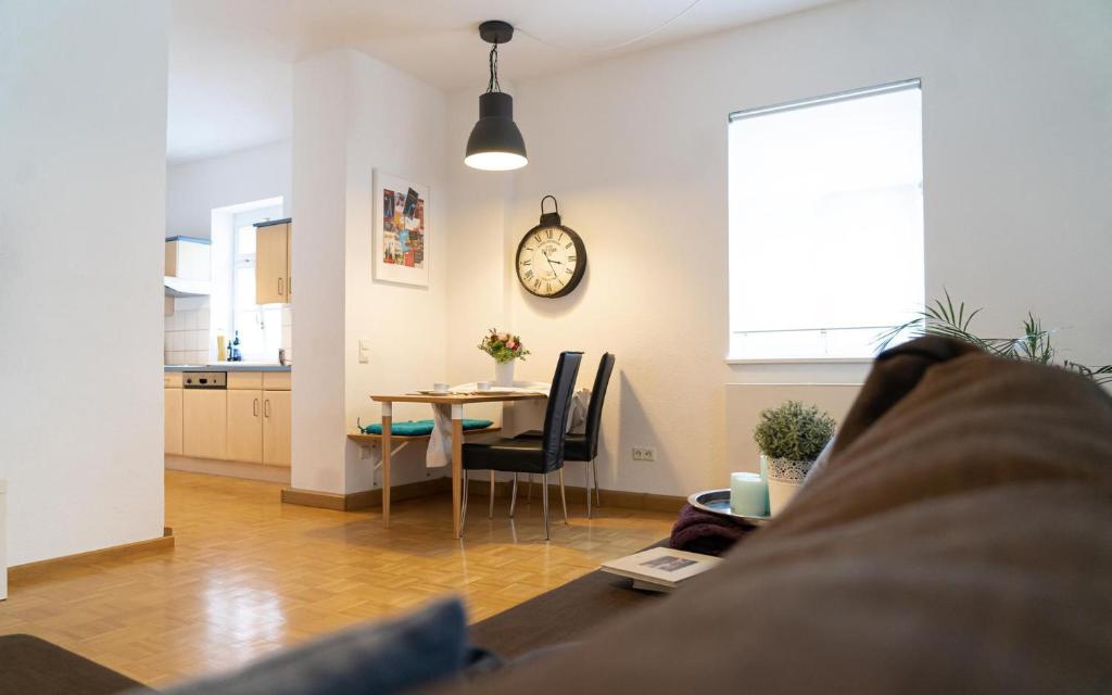 een woonkamer met een tafel en een klok aan de muur bij Old Town Apartment in Rottweil