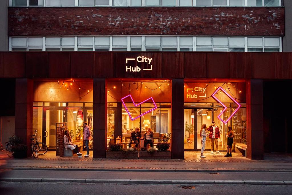 a store front with a neon sign on the front of it at CityHub Copenhagen in Copenhagen