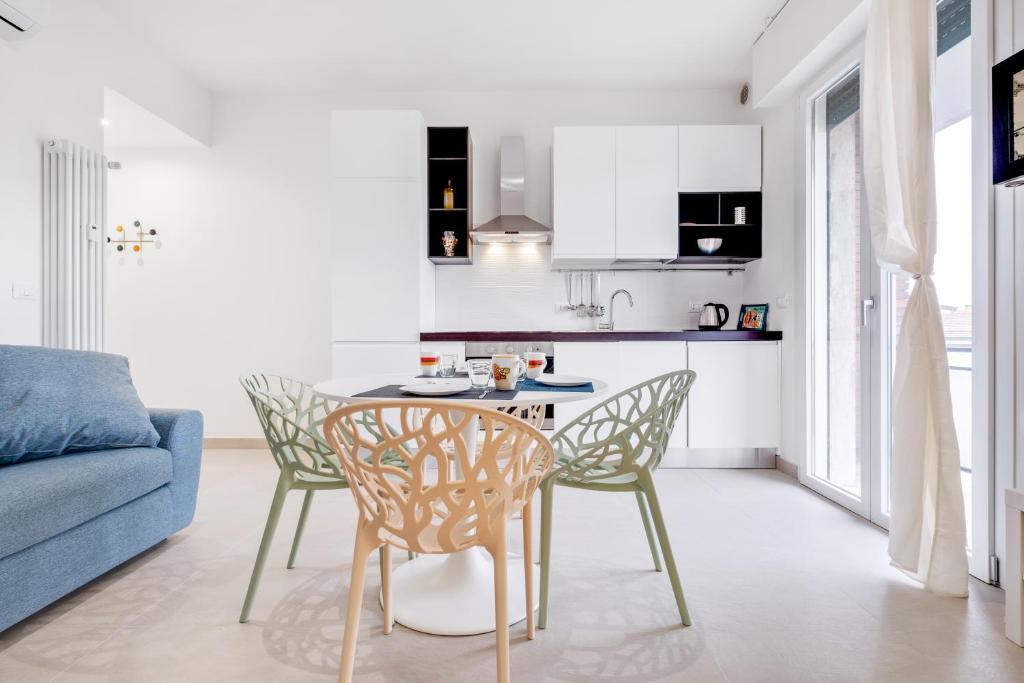 Il comprend une cuisine et un salon avec une table et des chaises. dans l'établissement Vista su San Luca Apartment, à Bologne