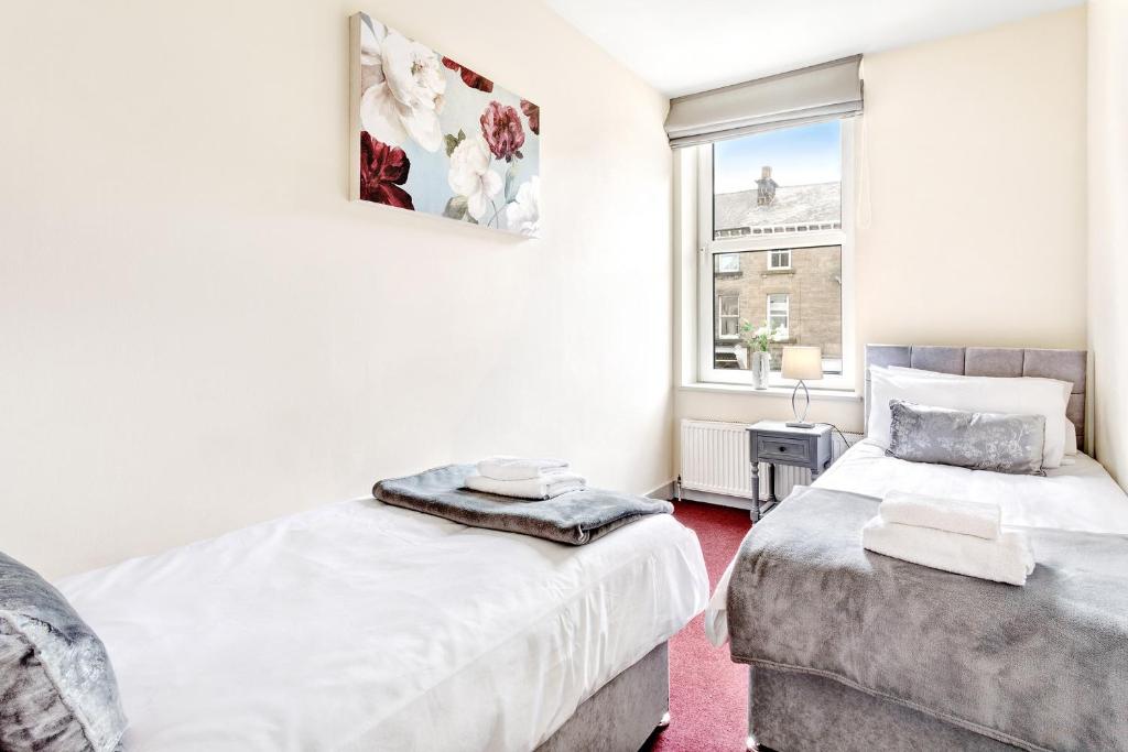 a bedroom with two beds and a window at Granville Apartments in Harrogate