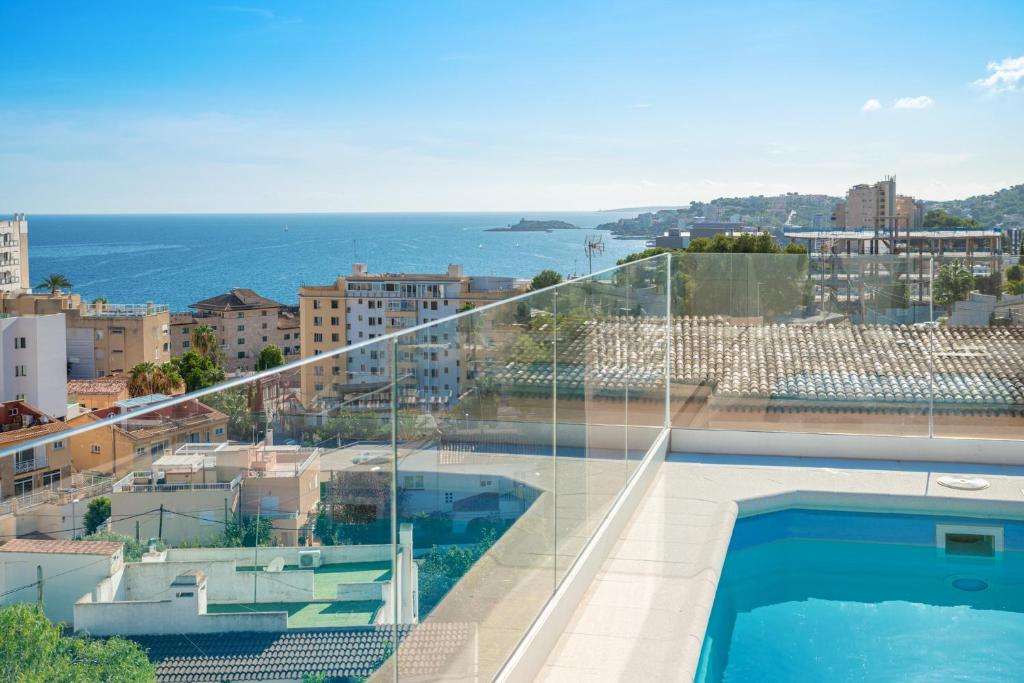 uma varanda com uma piscina e vista para o oceano em Villa Harmonía en Palma piscina/mar/playa em Palma de Maiorca