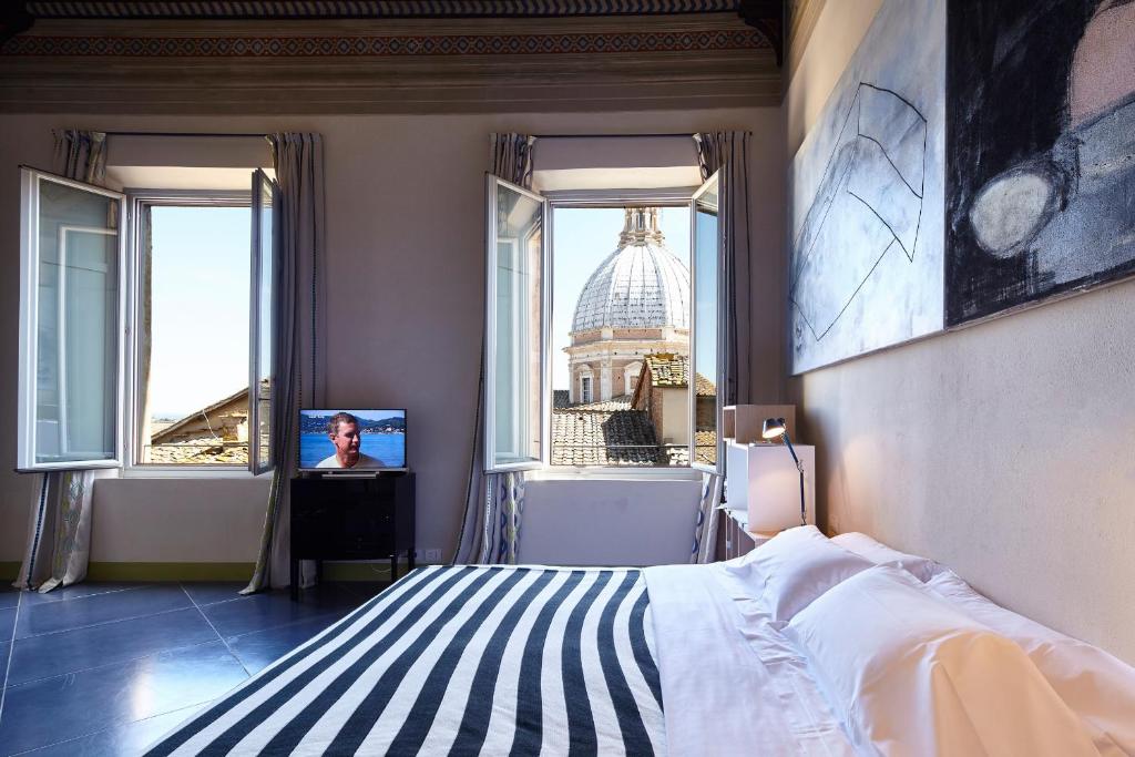 a bedroom with a bed and a view of a building at Palazzetto Rosso - Art Hotel in Siena