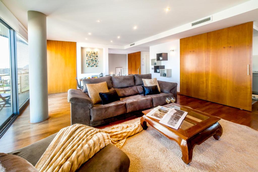 ein Wohnzimmer mit einem Sofa und einem Tisch in der Unterkunft Victoria Diagonal Mar Barcelona in Barcelona