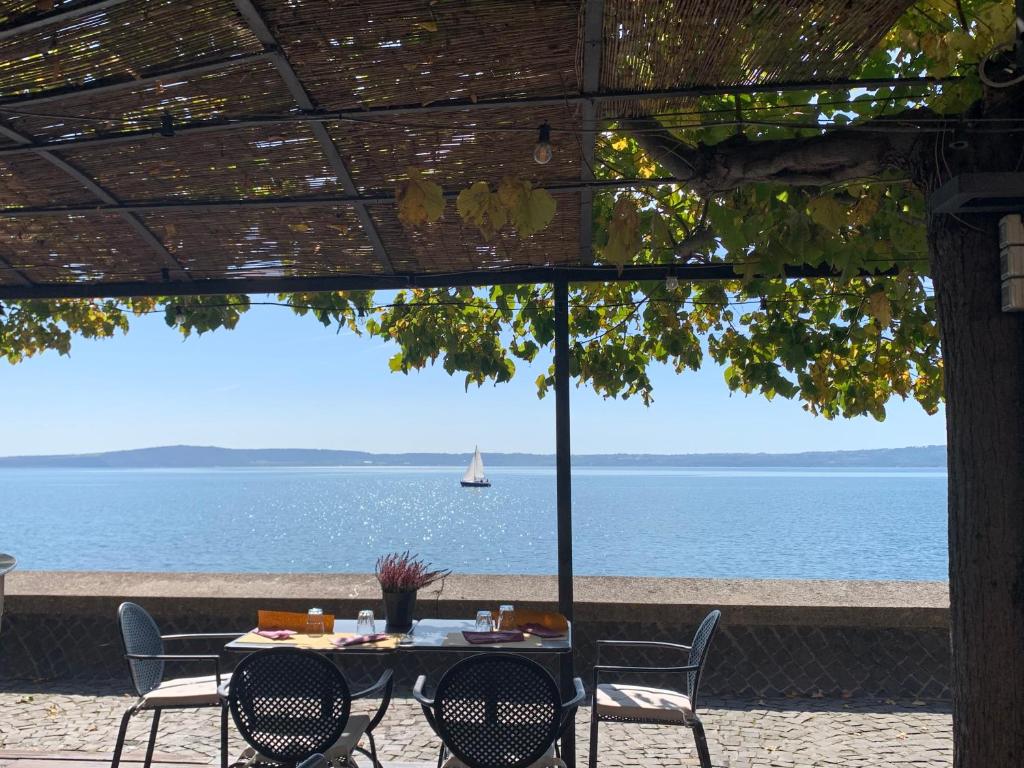 a table and chairs with a view of the ocean at Hotel Borgo Vistalago in Trevignano Romano
