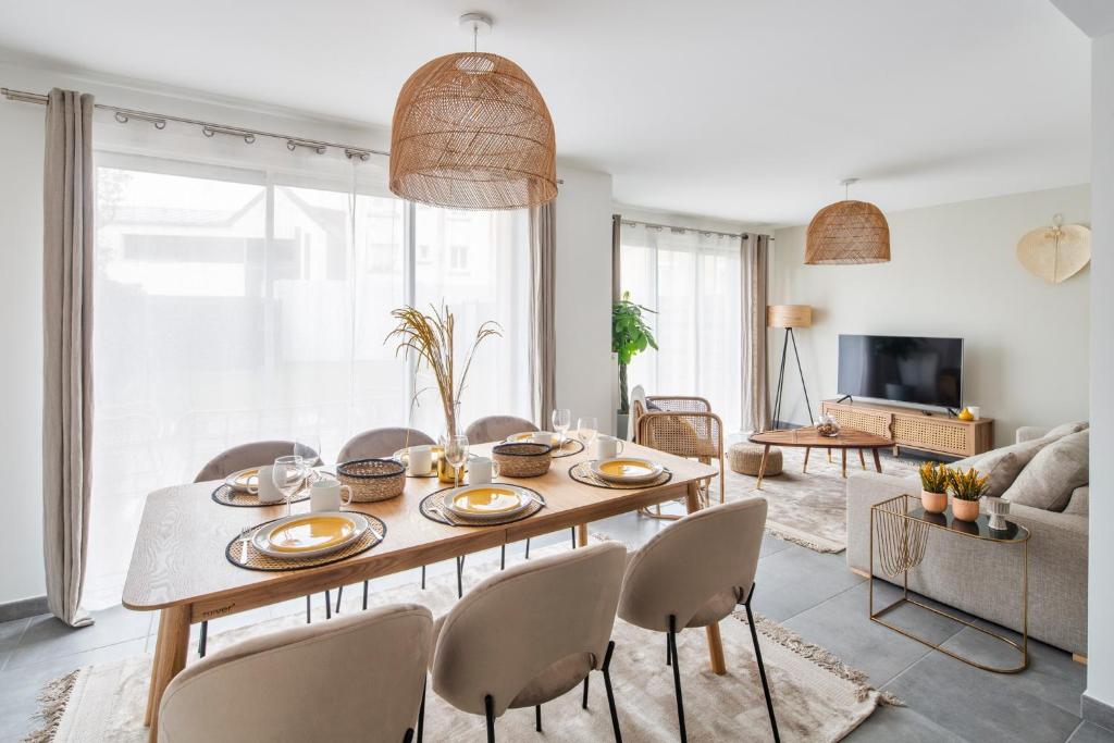 uma sala de estar com uma mesa de madeira e cadeiras em Maison Elleviou - Grande Maison à deux pas du centre em Rennes