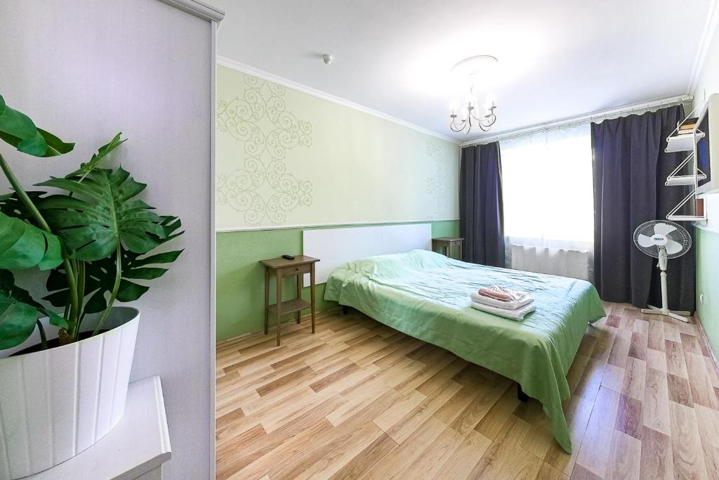 エカテリンブルクにあるEtazhiDaily Soyuznayaのベッドルーム(ベッド1台、鉢植えの植物付)