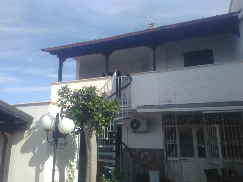 een wit huis met een boom ervoor bij Villa Cesarea in Porto Cesareo