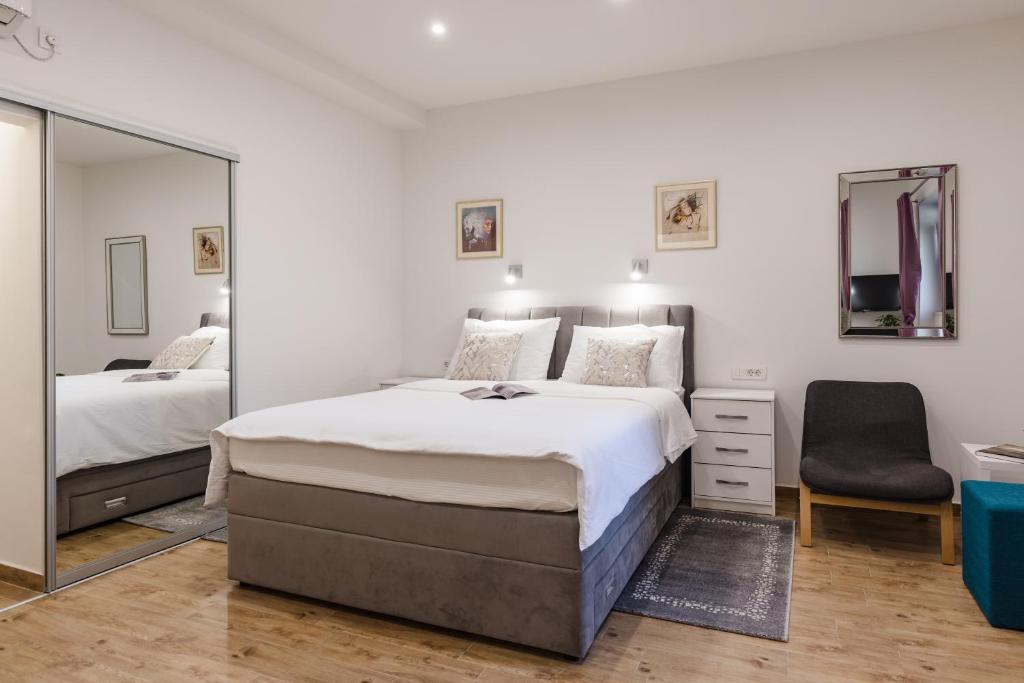 - une chambre avec un grand lit et un miroir dans l'établissement Apartments Martha, à Dubrovnik