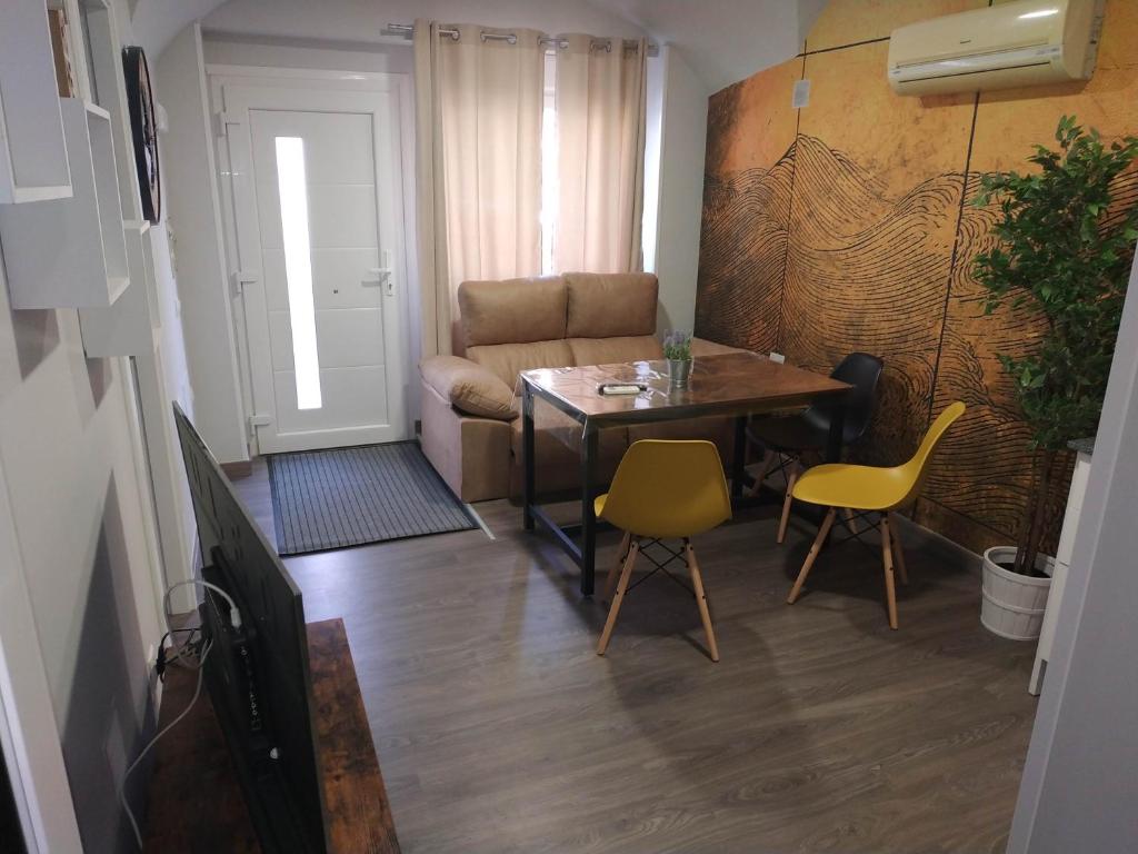 een woonkamer met een tafel en stoelen en een bank bij Alqazeres Confort in Cáceres