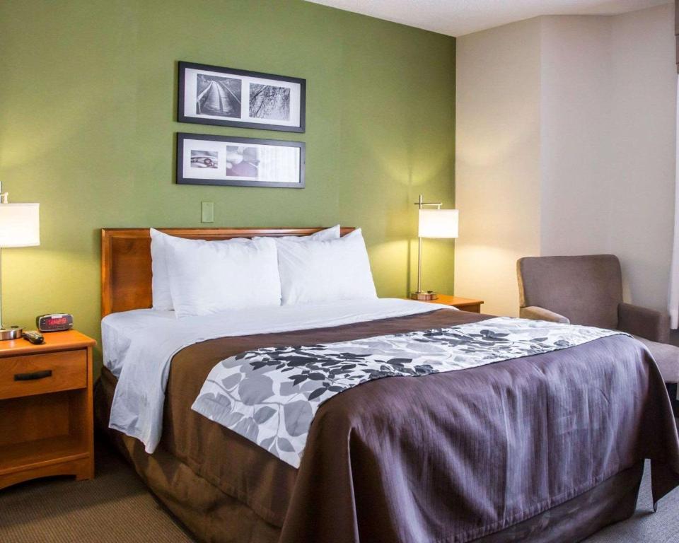 a hotel room with a bed and a chair at Sleep Inn Midway Airport Bedford Park in Chicago