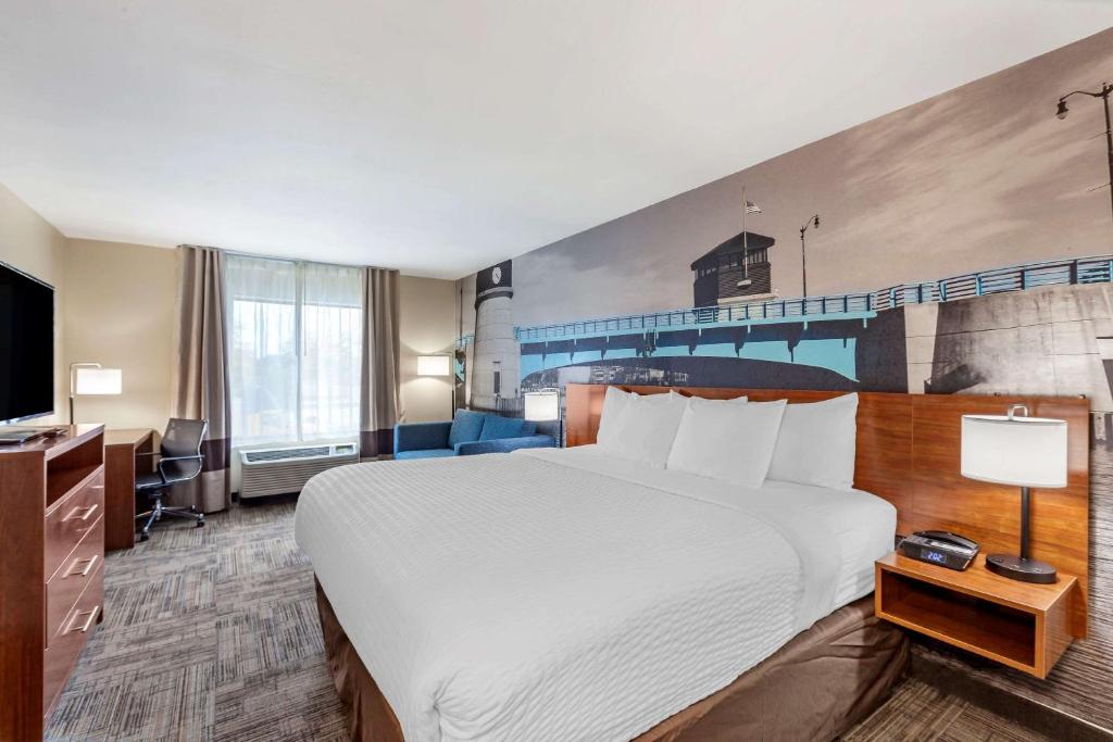 a hotel room with a large bed and a tv at Clarion Pointe Racine - Mount Pleasant in Racine