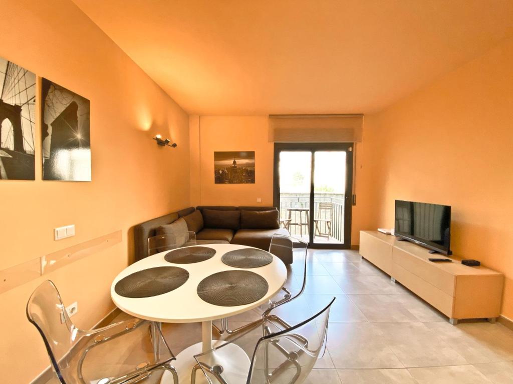 uma sala de estar com uma mesa e um sofá em Urban Manresa-City center apartment with balcony em Manresa