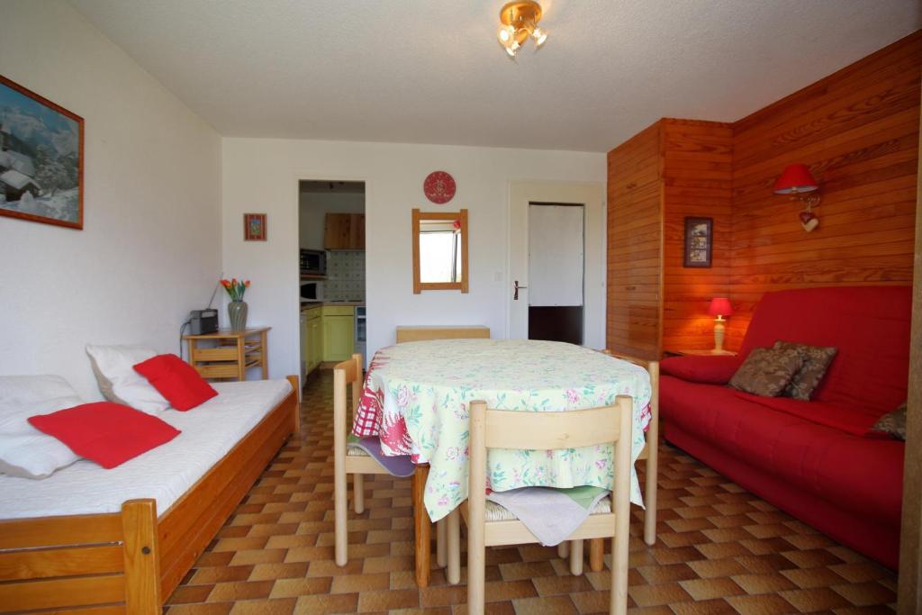 - une chambre avec deux lits et un canapé rouge dans l'établissement PE255 Studio 4 pers pieds de piste, aux Carroz d'Arâches