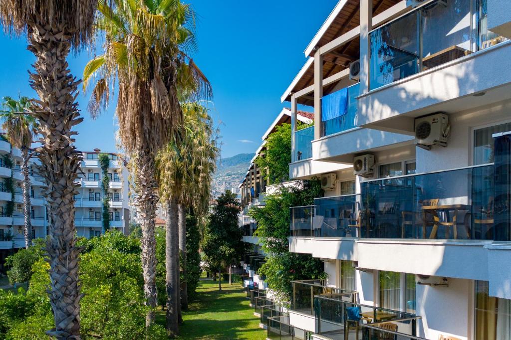 een rij palmbomen voor een gebouw bij Panorama Hotel - All Inclusive in Alanya