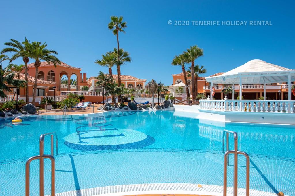 uma grande piscina num resort com palmeiras em Tenerife Royal Gardens - Viviendas Vacacionales em Playa de las Americas