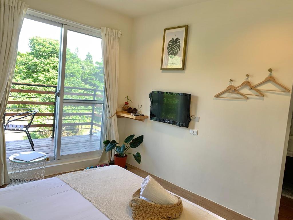 a bedroom with a bed and a tv on the wall at W24墾丁民宿墾丁大街一館bnb in Kenting