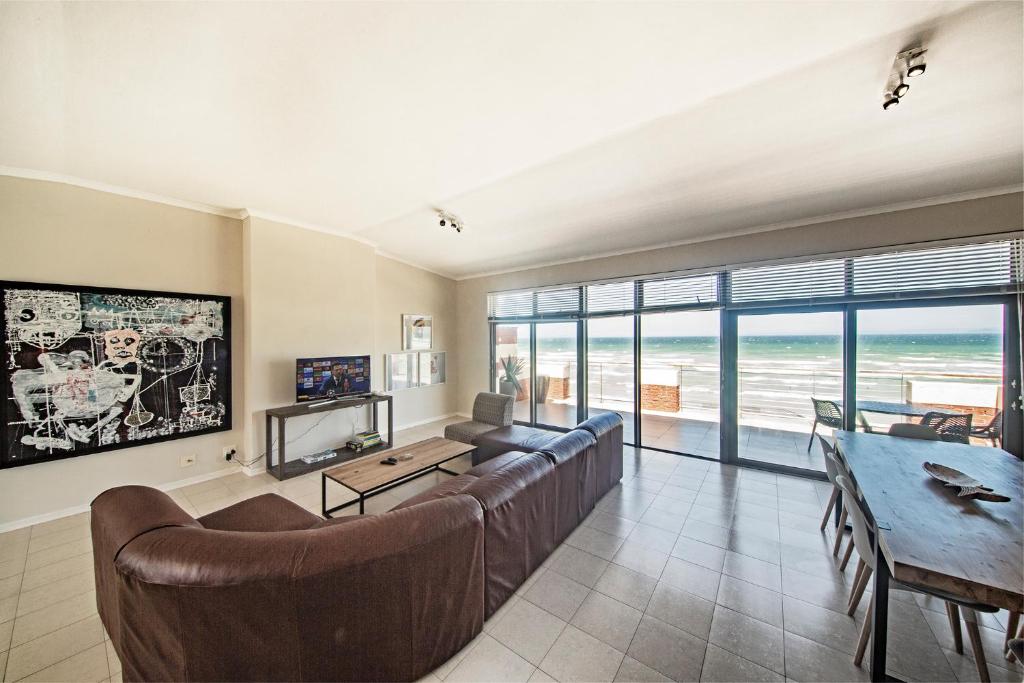 a living room with a couch and a table at Surferscorner Self Catering Apartments in Muizenberg