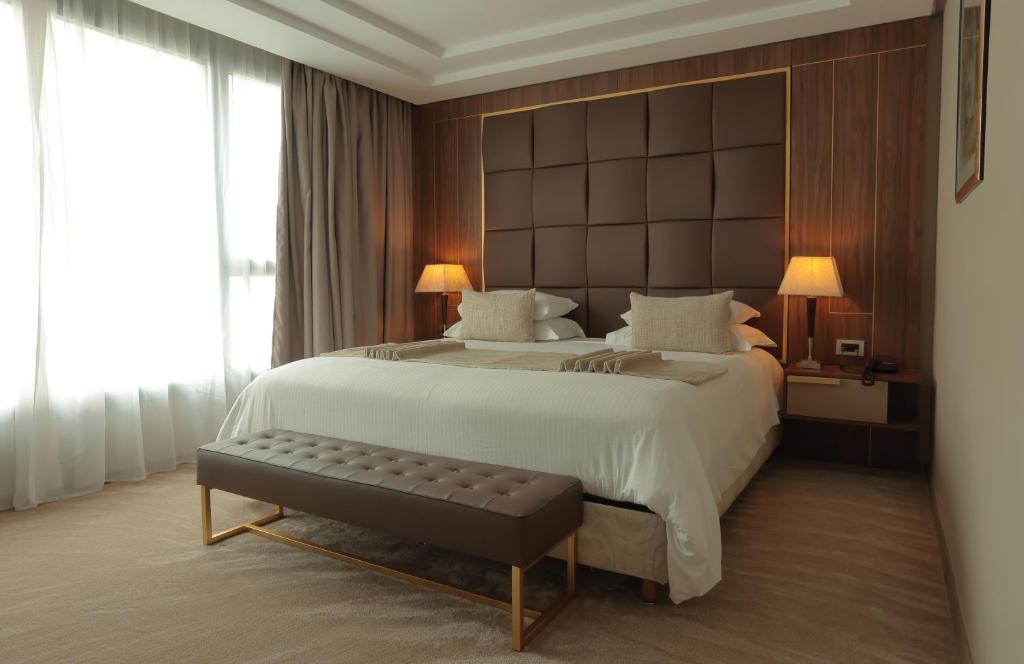 a bedroom with a large white bed and a bench at Le Palace d'Anfa in Casablanca