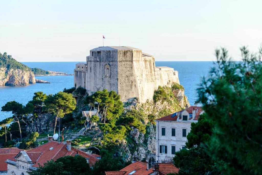 un castillo en una colina junto al agua en Apartments Dubrovnik Seven, en Dubrovnik