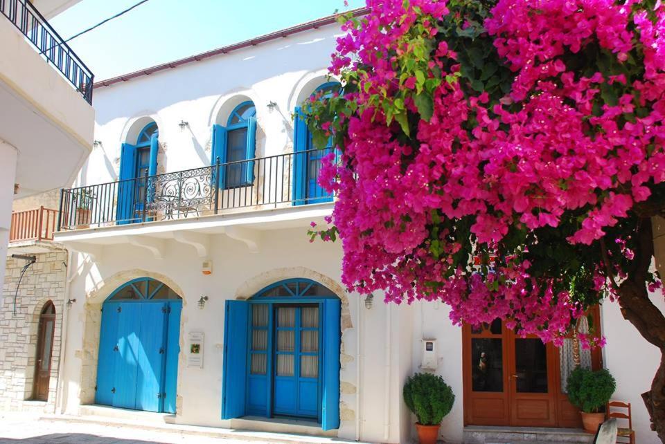 パノルモス・レティムノにあるVilla Aposperitisの青い扉とピンクの花の建物
