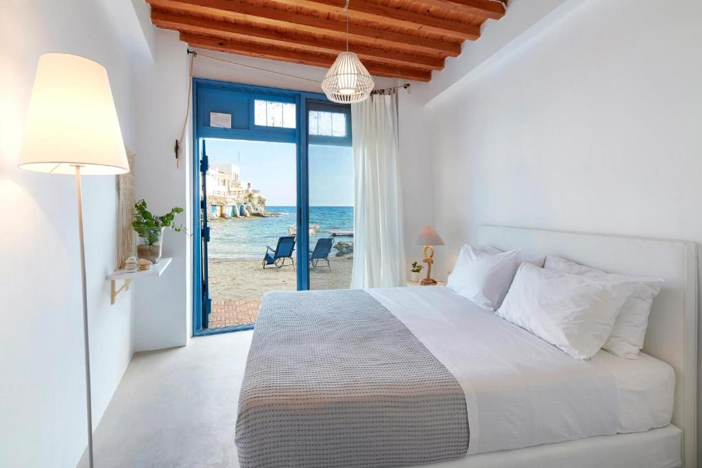 Schlafzimmer mit einem Bett und Meerblick in der Unterkunft The Elephant Beach House in Kimolos