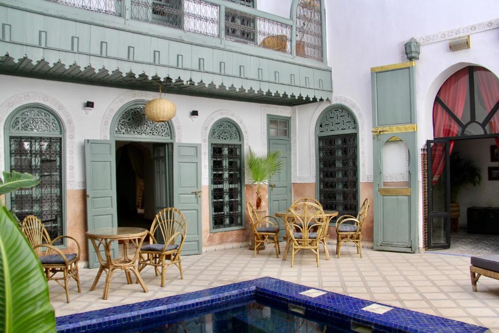 a patio with a table and chairs and a pool at Riad Sierra in Marrakesh
