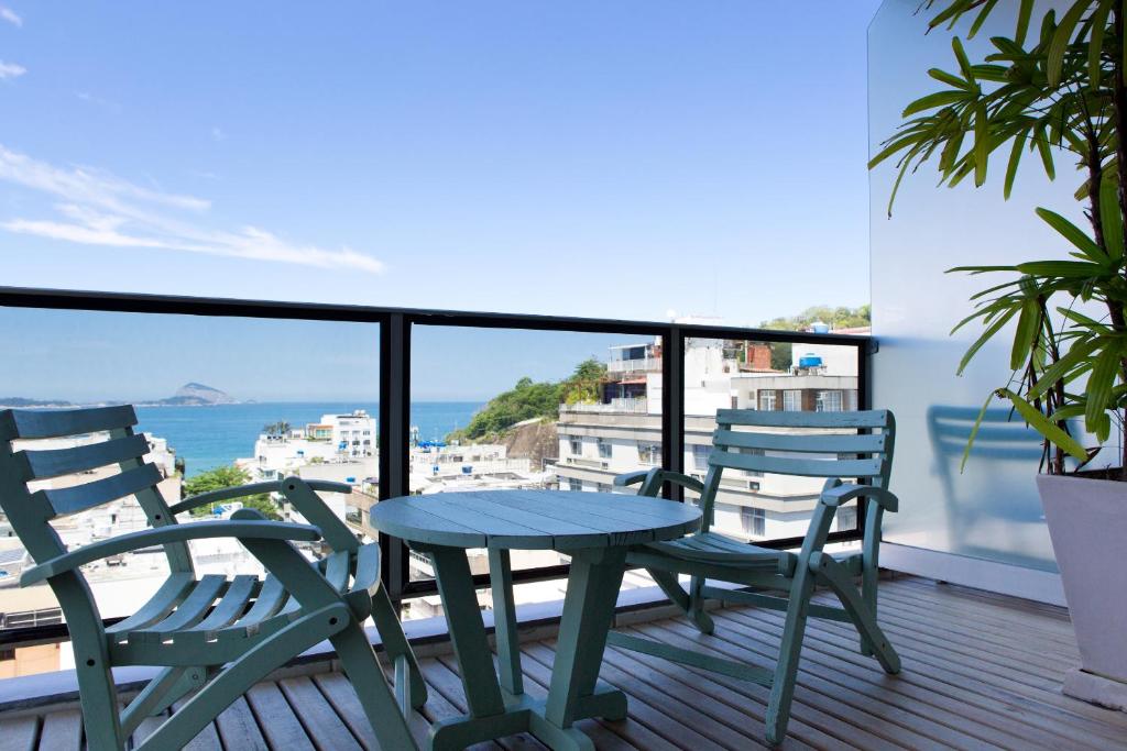 una mesa y sillas en un balcón con vistas al océano en Ritz Leblon, en Río de Janeiro