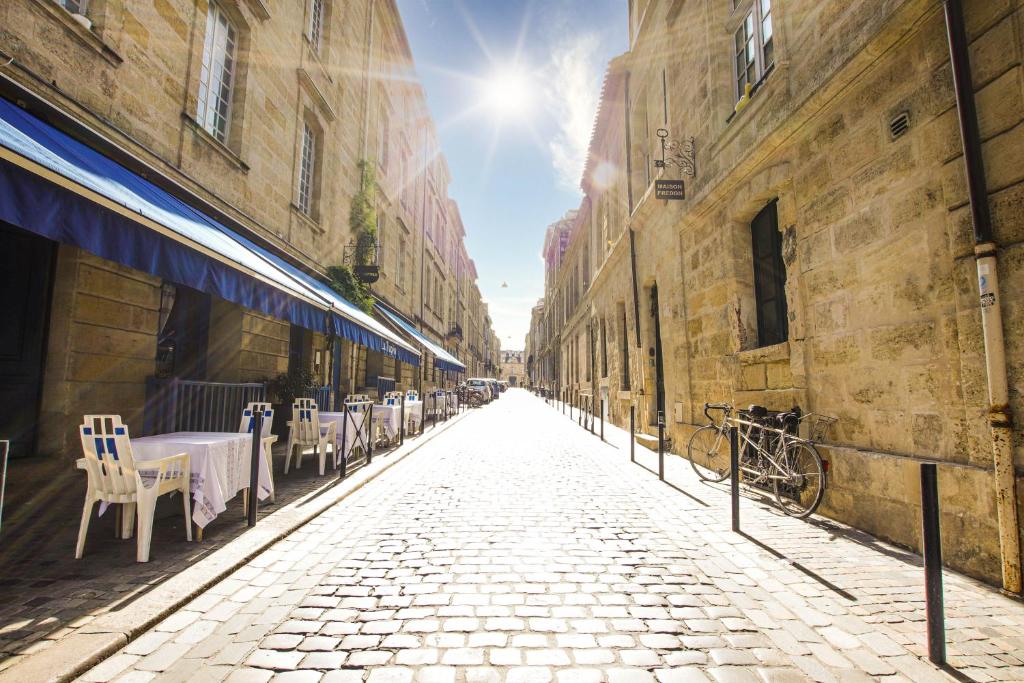 a cobblestone street with tables and chairs in an alley at Maison Fredon Bordeaux Centre in Bordeaux