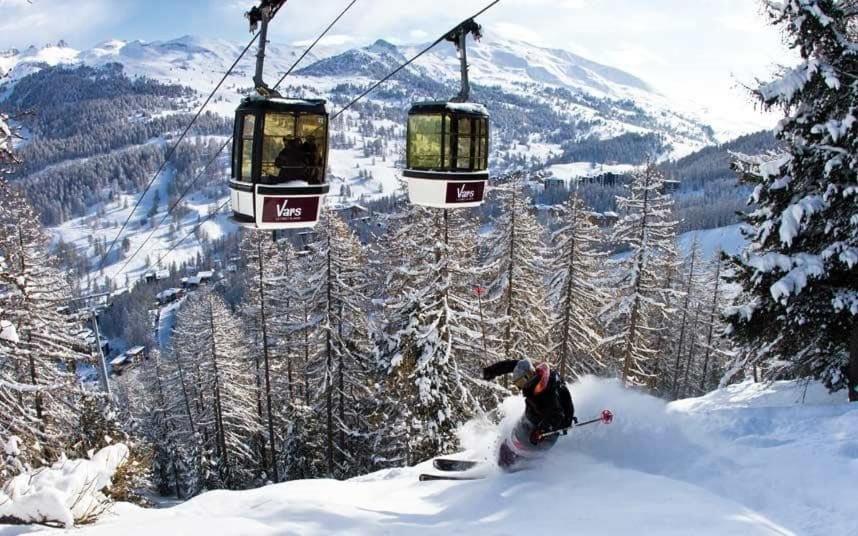 une personne skier sur une piste enneigée sous une remontée mécanique dans l'établissement Boost Your Immo Canteneige Sainte Marie 391, à Vars