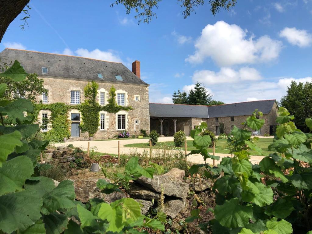 una antigua casa de piedra con un jardín delante de ella en Château de la Garnison en Orvault