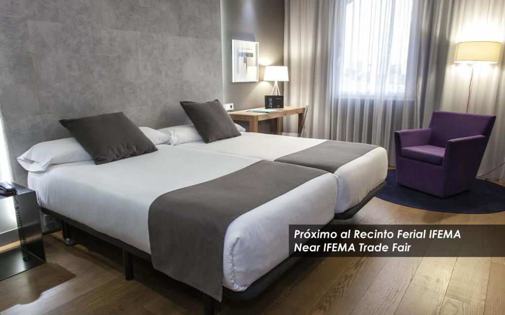 Habitación de hotel con cama grande y silla morada en Zenit Conde de Orgaz en Madrid