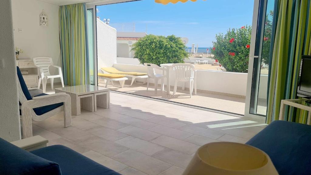 uma sala de estar com vista para um pátio com cadeiras em Albufeira, with terrace, see views, 5 min to beach (21) em Albufeira